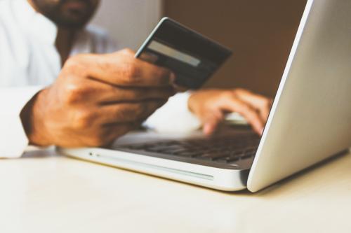 Man using laptop and holding credit card